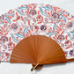 Éventail Rosalie en coton à motifs floraux corail, bleu et terracotta avec monture en bois naturel, fabriqué artisanalement en Provence.